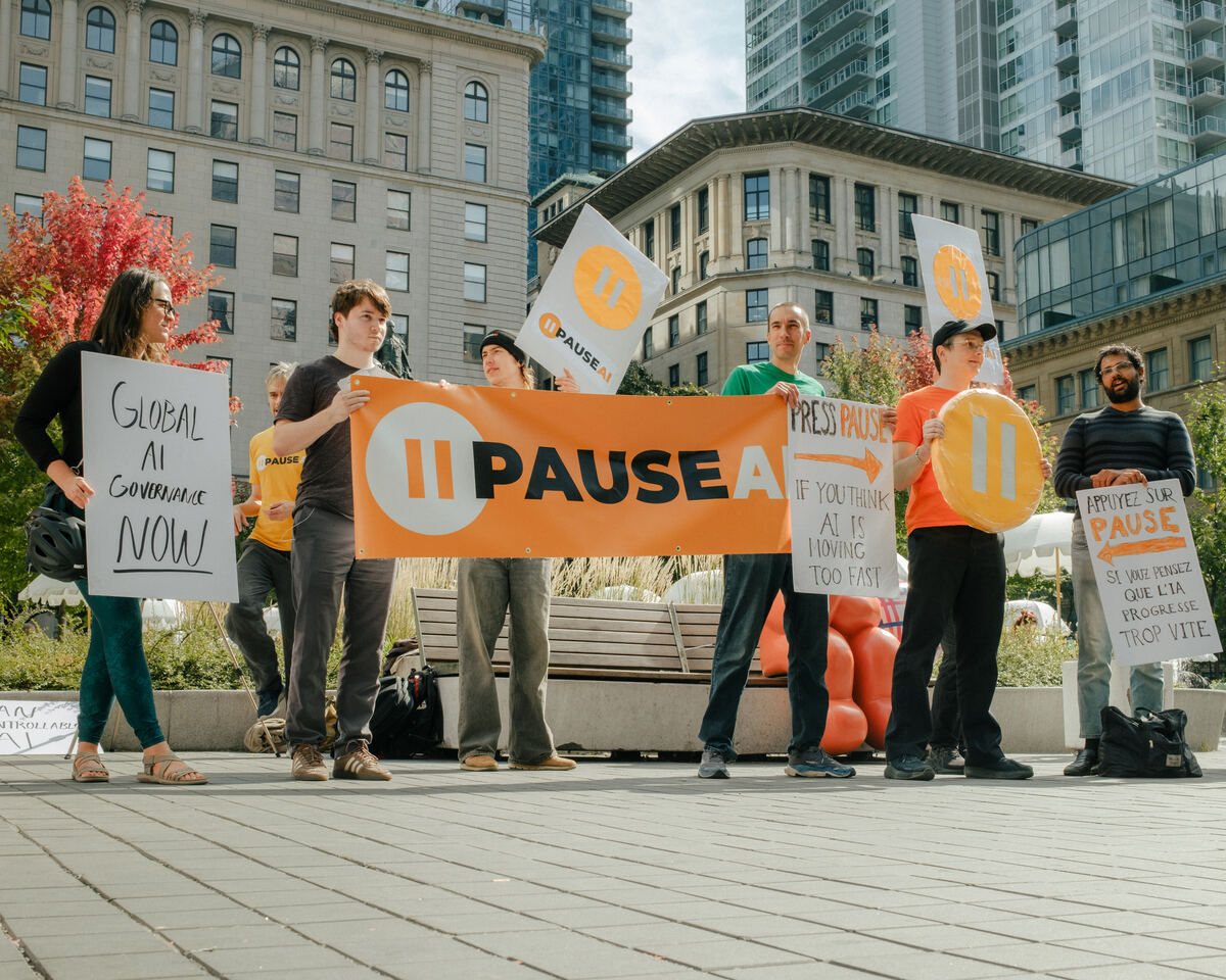 Des manifestants portent une bannière PauseIA et des pancartes au square Phillips